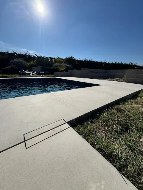 Carrelage clair terminé au bord de la piscine sous le soleil